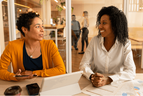 two business women meeting to discuss commercial electricity meter installation requirements.